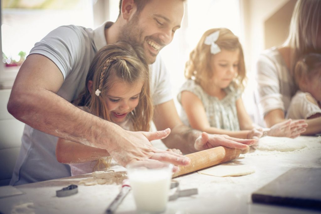Papa backt mit den Kindern Plätzchen.