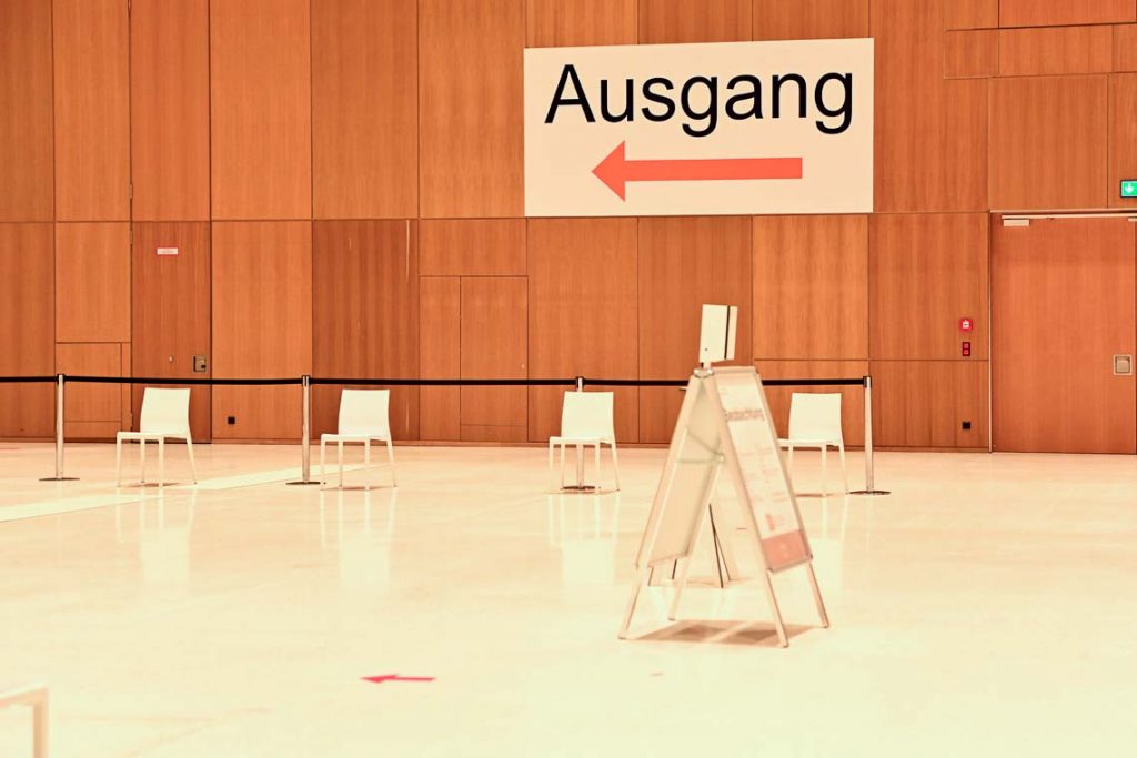 Wegweiser zum Ausgang im Impfzentrum