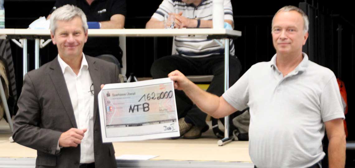 Andreas Kowol überreicht Andreas Forster einen Scheck über 162000 Euro