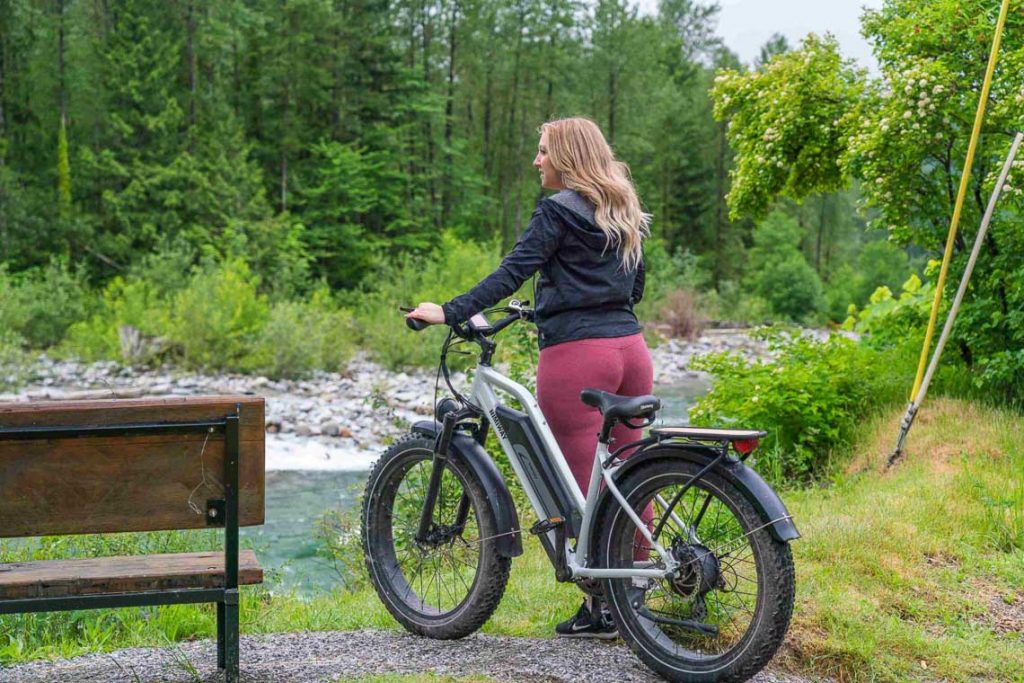 Frau mit einem E-Bike unterwegs im Wald.