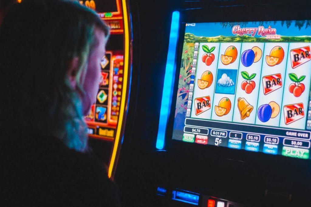 Person vor Spielautomat