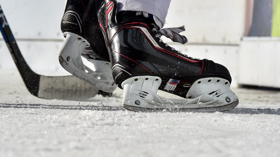 Ein paar Schlittschuhe bremsen auf dem Eis.