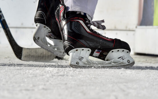 Ein paar Schlittschuhe bremsen auf dem Eis.