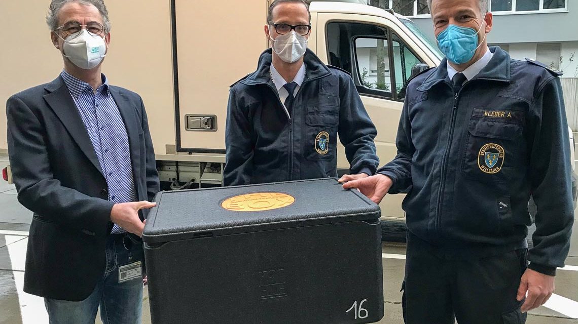 Martin Hofmann, leitender Apotheker des Impfzentrums, sowie Marc Dieroff und Andreas Kleber von der Leitung des Impfzentrums nehmen den neuen Impfstoff in Empfang.