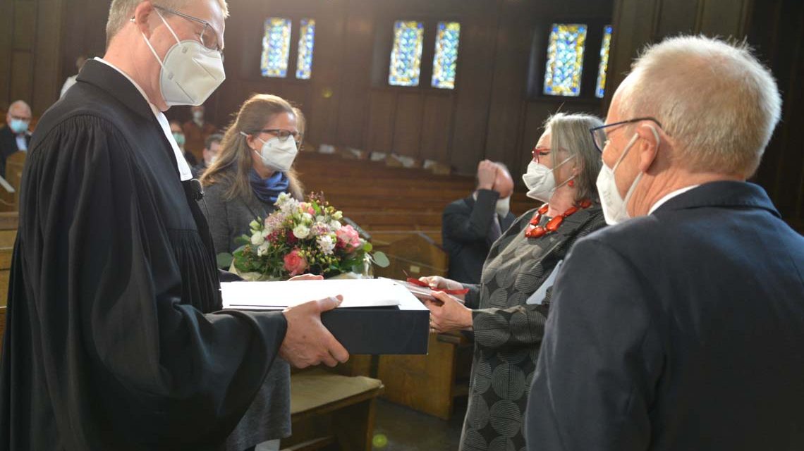 Wein und Blumen zum Abschied: Eberhard Busch (vorne rechts), Vorsitzender des Dekanatssynodalvorstands, und Präses Gabriele Schmidt verabschieden sich vom stellvertretenden Dekan Matthias Welsch (links) und seiner Frau (rechts daneben).