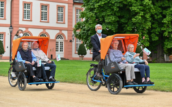 „Radfahren gemeinsam neu entdecken“ Ehrenamtlich Helfer hatten auf Initiative des Vereins „Radeln ohne Alter Deutschland e.V. Senioren des EVIM Katharinenstift abgeholt um mit Ihnen eine Runde durch den Biebricher Schloßpark zu radeln. Andreas Kowol kutschierte Maria Dörner und Johanna Elbert durch die Gegend. Stadträtin Ella Bai Hermann Martin und Adam Kriechbaum. Foto: Volker Watschounek