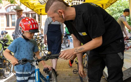 Fahrradfest: Fahrradreparatur und Fahrradcheck mit Lucky Bike: Kai Ehmann hat die Bremse von Konstantins Fahrrad nachgestellt. Foto: Volker Watschounek