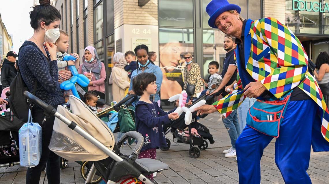 Künstler macht aus einem Luftballon einen Hund und erfreut einen kleinen Jungen.