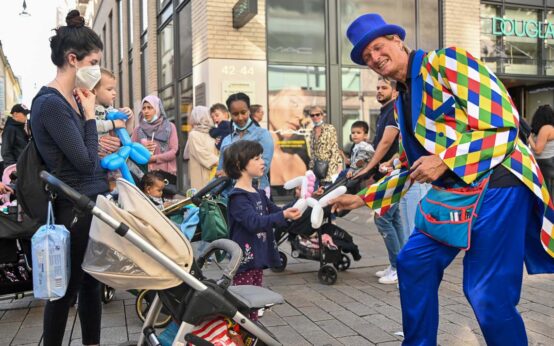 Künstler macht aus einem Luftballon einen Hund und erfreut einen kleinen Jungen.