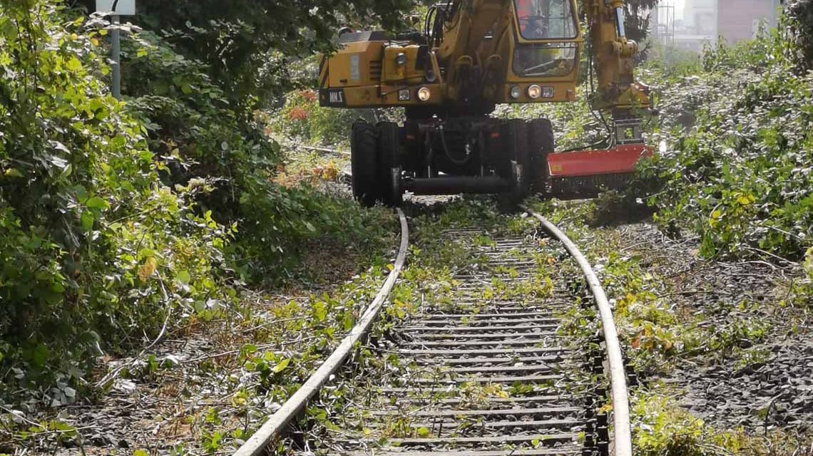 Bagger auf Schienen röäumt entlang der Aartalbahn auf.