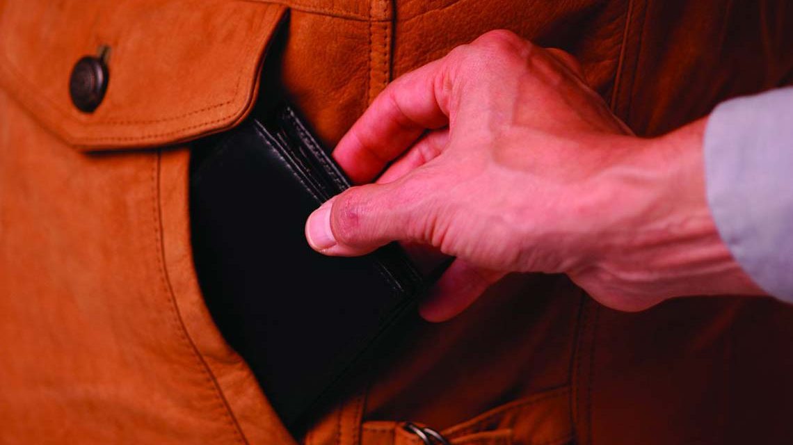 Mann greift einem fremden in die Tasche und zueht Geldbörse heraus: Taschendiebstahl in der Öffentlichkeit