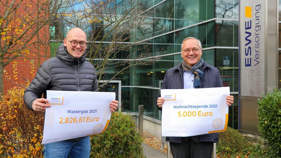 Torsten Urbich (l.) von „Die Sternschnuppen“ und Ralf Schodlok bei der Scheckübergabe vor dem Haupteingang der ESWE-Zentrale: Spende für krebskranke Kinder.