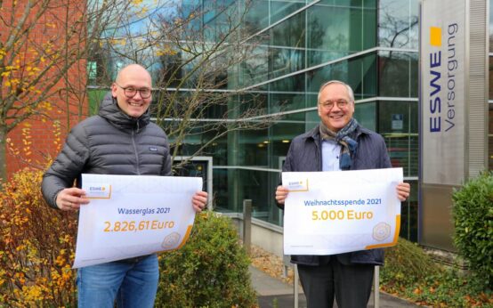Torsten Urbich (l.) von „Die Sternschnuppen“ und Ralf Schodlok bei der Scheckübergabe vor dem Haupteingang der ESWE-Zentrale: Spende für krebskranke Kinder.