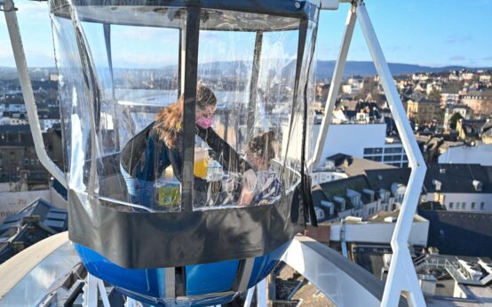 Schwester Maria impft über den Dächern von Wiesbaden im Impf-Riesenrad.