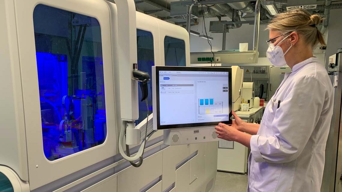 Dr. Christine Schindel kontrolliert das neue PCR-Testgerät, das bis zu 3.000 PCR-Tests innerhalb von 24 Stunden analysieren kann.