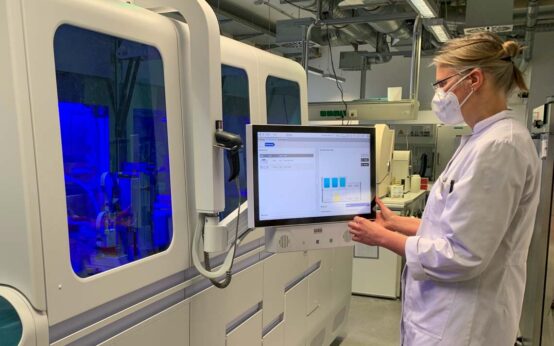 Dr. Christine Schindel kontrolliert das neue PCR-Testgerät, das bis zu 3.000 PCR-Tests innerhalb von 24 Stunden analysieren kann.