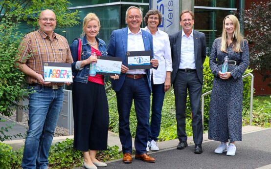 Die Wasserglas-Jury mit den Gewinner-Motiven 2022 (v. l.): Robert Hammann (Leiter ESWE-Wasserstand), Sabine Stang (Mediengestalterin), Ralf Schodlok (Vorstandsvorsitzender ESWE Versorgungs AG), Anke Auen (Unternehmenskommunikation ESWE Versorgung), Frank Rolle (Leiter Unternehmenskommunikation ESWE Versorgung) und Sina Schreiner (Lokalredakteurin).