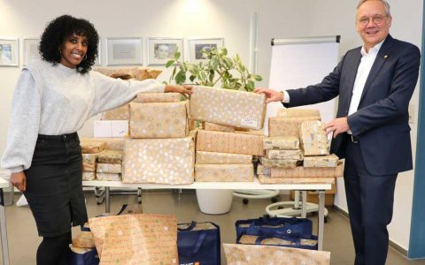 Zwei Personen stehen vor einem Haufen von Geschenken, einer davon ist Vorstandsvorsitzender Ralf Schodlok.