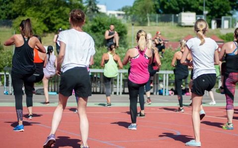 Jugendliche auf dem Sportplatz beim Zumba.