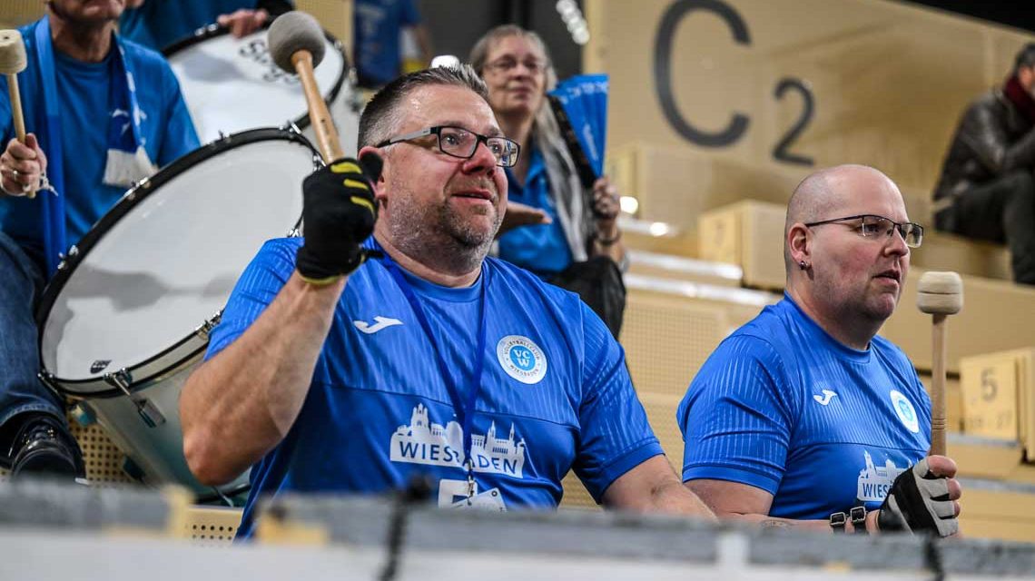 Baue Wand, der fünfte Mann in der Sporthalle am Platz der deutschen Einheit. Fans, die Wiesbadens Volleyballerinnen mit Pauken unterstützen.