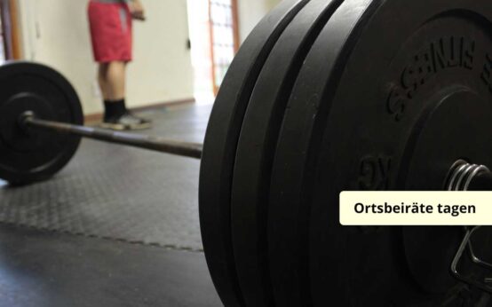 Handelstage in einem Kraftraum, idahinter steht ein Mann.