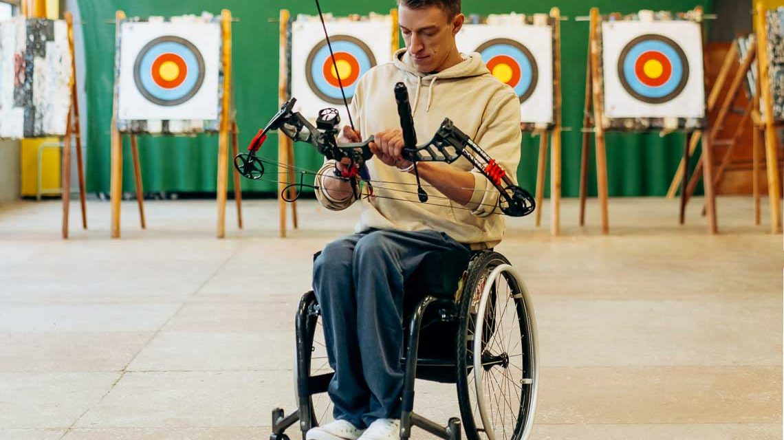 Rollstuhl Bogenschießen in der Sporthalle beim Training, Gastgeber-Programm