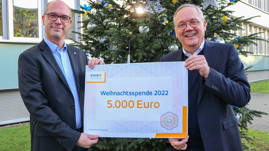 Ulf Weyer und Ralf Schodlok mit Scheck vor dem Gebäude von ESWE