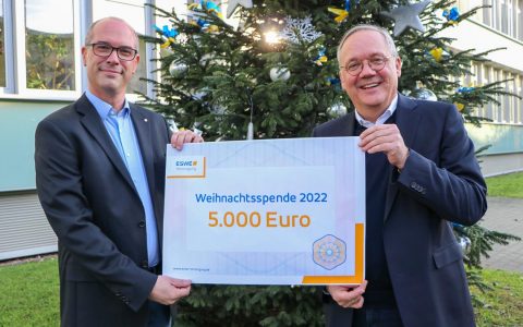 Ulf Weyer und Ralf Schodlok mit Scheck vor dem Gebäude von ESWE