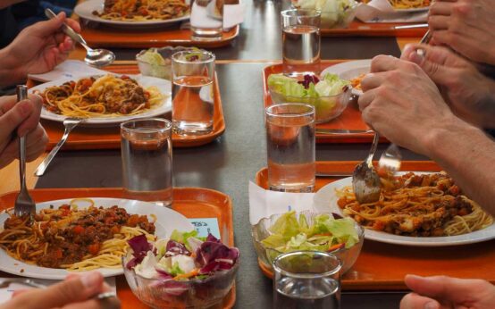 Tisch mit vielen Teller: Schulmensa, Schulessen.