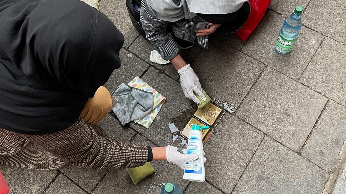 Zwei Frauen reinigen Stolpersteine in Wiesbaden.
