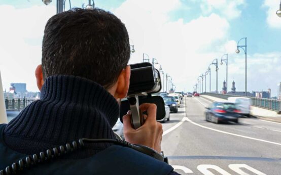Polizist misst die Geschwindigkeit mit einem neuen Lasergerät.