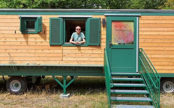 Christoph Manjura schaut aus einem Bauwagen heraus.