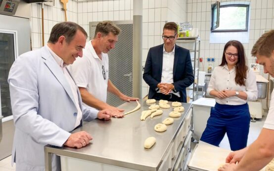 Prof. Dr. R. Alexander Lorz mit zwei Auszubildenden und Mitarbeitern des HKM.