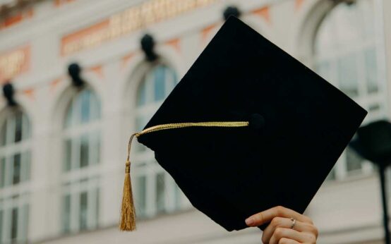 Diplom, Absolvent hält seinen Hut in die Luft