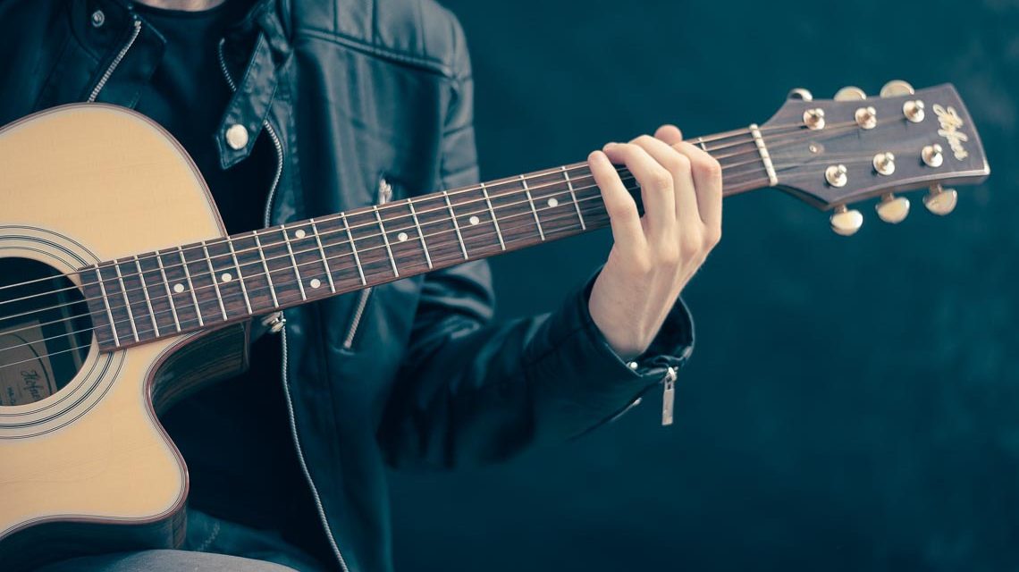 Ton ab: Person mit Gitarre in den Händen.
