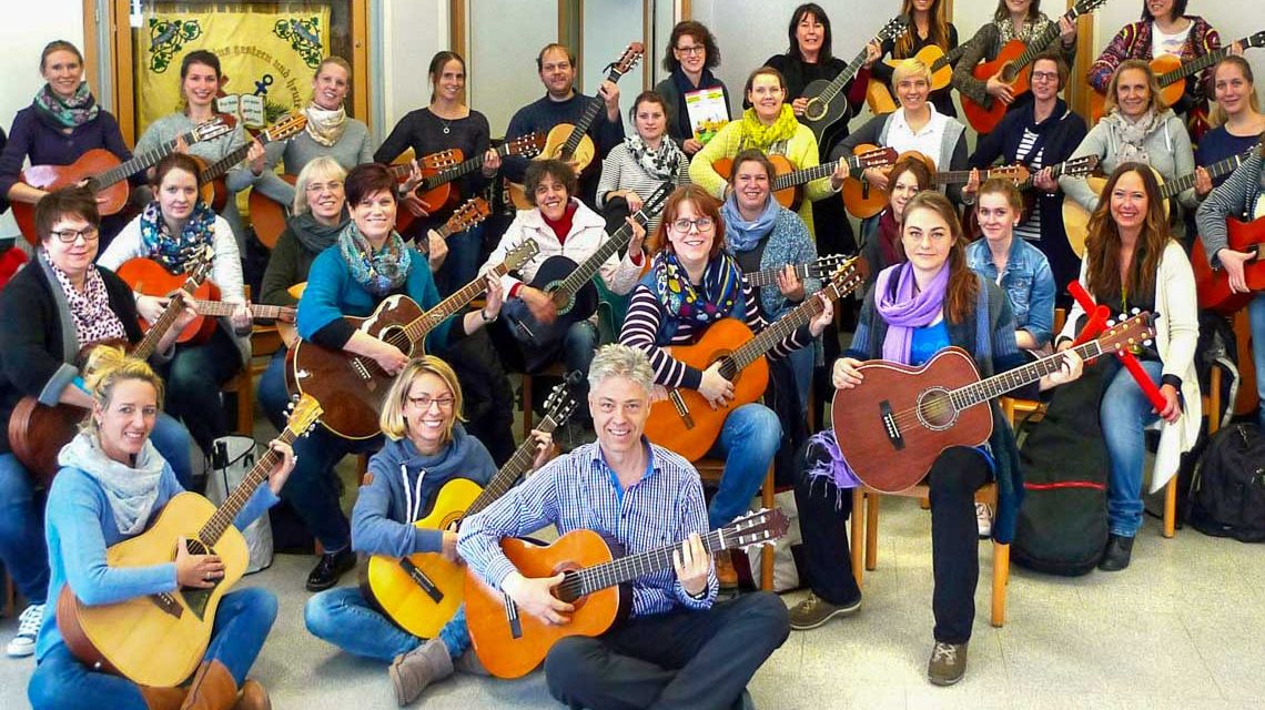 Ganz viele junge Erwachsene mit Gitarre