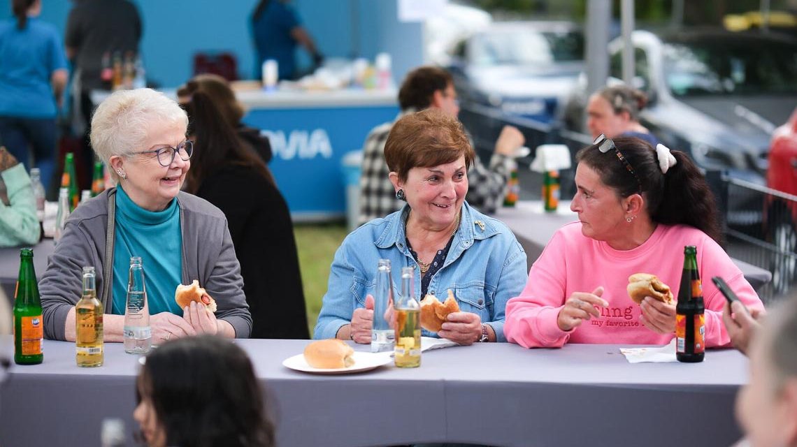 Mieter sitzen beim Fest zusammen und tauschen sich aus.