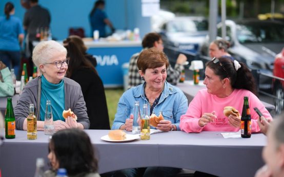 Mieter sitzen beim Fest zusammen und tauschen sich aus.
