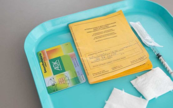 Symbolbild: Impfsprechstunde, Impfpass, Spritze, Versicherungskatrte
