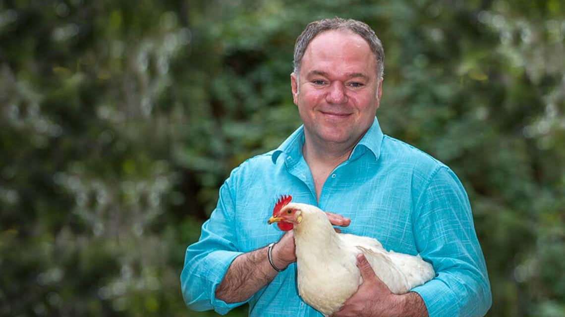 Serhat Dogan mit einem Huhn oder Hahn im Arm.