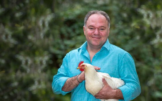 Serhat Dogan mit einem Huhn oder Hahn im Arm.