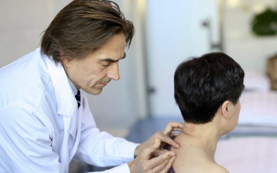 Arzt behandelt einen Patienten. tagesstationäre Behandlung.