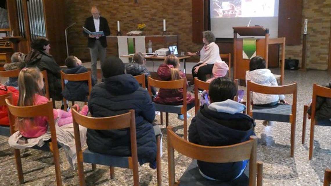 Vorlesetag am Gräselberg: Kinder sitzen in der Lukaskirche und hören gebannt zu.