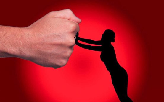 Frau schiebt die Faust eines Mannes weg, Gewalt gegen Frauen. Frauenhäuser helfen weiter.