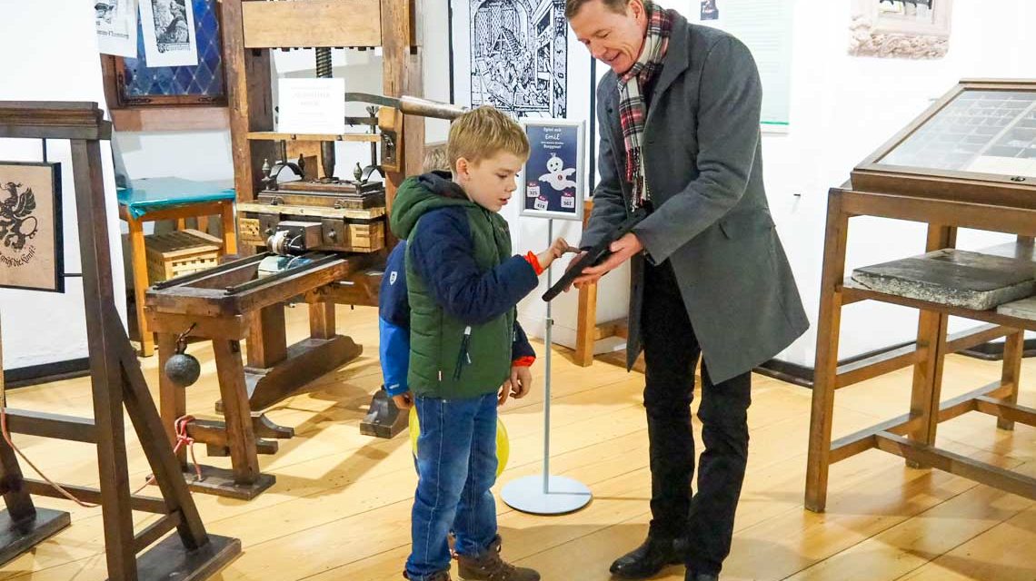 Eltville: Die kleinen Burggäste Silas und Matteo testen gemeinsam mit Thomas März, Geschäftsführer des Burgvereins, das Emil-Quiz in der Gutenbergausstellung