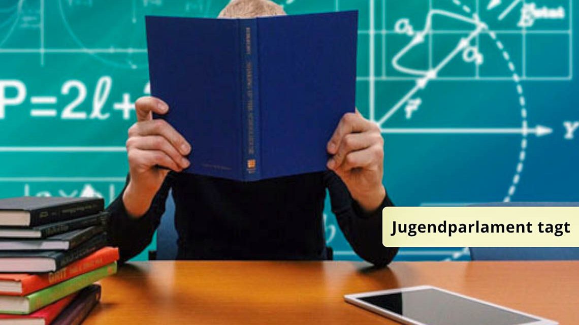 Schüler sitzt vor einer Tafel und lernt