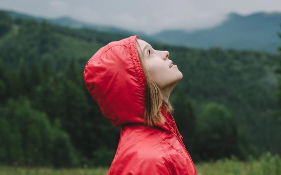 Frau schaut in den Himmel nach dem Wetter