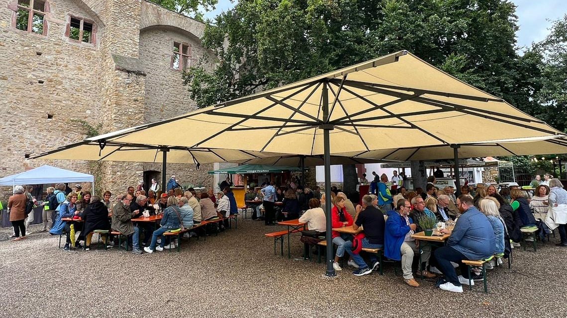 Ehrenamt in Eltville, Burg im Hintergrund, aufgespannte Schirme