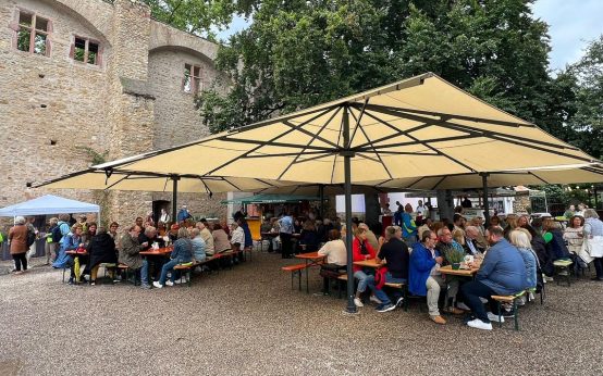 Ehrenamt in Eltville, Burg im Hintergrund, aufgespannte Schirme