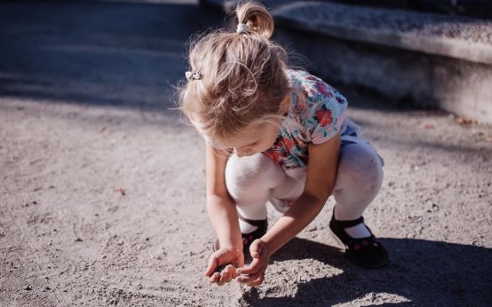 Kleines Kind spielt alleine im Sand.
